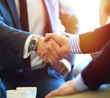 businessman shaking hands around coffee